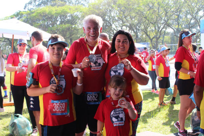 Família carregando medalha no peito após o término da corrida